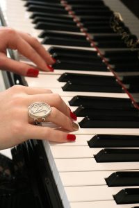 Woman playing piano, wearing beautiful Aramaya ivory ring